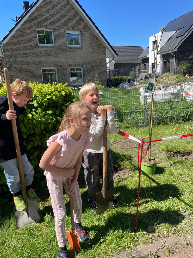 Vor einigen Wochen wurden wir von der befreundeten Kardinal-von-Galen Grundschule zu einer Baumpflanzchallenge eingeladen und haben diese nun erfolgreich gemeistert. Ein zwei Meter großer Walnussbaum schmückt nun seit dem 29.04. unseren Lehrerparkplatz und wird bestimmt gut gehegt und gepflegt. Die fleißigen Baumpflanzhelfer aus dem zweiten Jahrgang sind ja schließlich noch zwei volle Jahre bei uns. Gute Voraussetzungen für stetes Wachstum unseren neuen Baumes. 