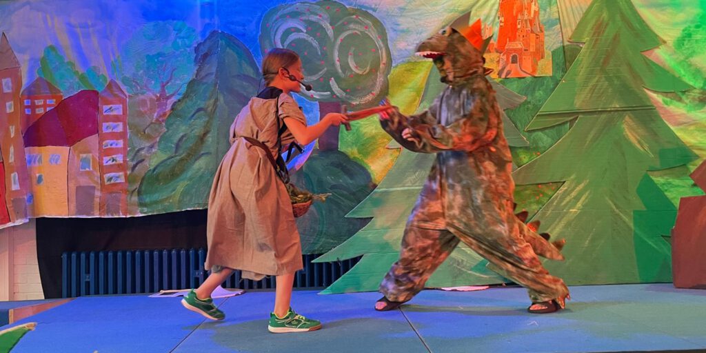 „Den Fluch besiegt“ – Hauenhorster Kinder führen Musical auf Und wieder einmal stand das aktive Schulleben der Marienschule aus Hauenhorst ganz im Zeichen des NRW- Landesprogramms „Kultur und Schule“, mit dessen finanzieller Unterstützung der Schulchor der Hauenhorster Grundschule im laufenden Schuljahr ein großartiges Musical auf die Bühne bringen konnte. Aufgeführt wurde in diesem Jahr das Musical „Drachenkämpfer - vom Bauernjungen zum Königssohn“ von Uli Führe und Babette Dieterich. Drei Mal wurde das Stück am vergangenen Freitag bei über 30 Grad Außentemperatur und bestimmt 40 Grad Innentemperatur in der stets voll besetzten Aula der Schule aufgeführt. Traditionell sind zur Generalprobe die kommenden Schulneulinge aus den Hauenhorster Kindergärten eingeladen und schauen sich gemeinsam mit den anderen Marienschülerinnen und -schülern die Generalprobe des jeweiligen Musicals an. Am Nachmittag durften/mussten die jungen Künstler dann noch zwei Mal vor den stolzen Augen der Eltern, Großeltern und Freunden ihre gesanglichen, instrumentellen, tänzerischen und schauspielerischen Fähigkeiten unter Beweis stellen. Die Zuschauer erlebten ein spannendes Musical, in dem es um einen furchterregenden Drachen geht, der Jahr für Jahr ein Mädchen des Königreiches fordert, um seine Wut zu besänftigen. Die Dorfbewohner leben in ständiger Angst, dass ihre Tochter ausgewählt und zum Drachen geschickt wird. Keinem Ritter ist es bisher gelungen, den Drachen zu besiegen. Der junge Burkhardt nimmt den Kampf mutig auf und erlöst den Drachen mit geheimnisvollen Kräutern und einer verzauberten Rüstung von seinem bösen Fluch. Am Ende bekommt der mutige Burkhardt als Dank die schöne Königstochter zur Frau. In bezaubernden Kostümen und verschiedensten Rollen zeigten die ca. 60 Mädchen und Jungen ihre schauspielerische und gesangliche Freude und Kompetenz. Zum Schluss aller drei Aufführungen gab es für alle Akteure einen riesigen Applaus und begeisterte Worte vom Schulleiter Christian Hülsmann. Seine warmen Worte (bei 40 Grad kann man das durchaus so bezeichnen) richteten sich gleichermaßen an die Kids als auch an die Künstlerin Brigitte Lesting und die Lehrkraft Sabine Müller für die beeindruckende Inszenierung dieses wunderschönen Stückes. Im Anschluss feierte die Schulgemeinschaft dann noch das ebenfalls traditionelle „Come together“ auf dem Schulhof und ließ den erfolgreichen und zum Glück trockenen Tag in gemütlicher Runde mit Popcorn, Zuckerwatte, Snacks, Grillwürsten im Brötchen und kalten Getränken ausklingen. „Den Fluch besiegt“ – Hauenhorster Kinder führen Musical auf Und wieder einmal stand das aktive Schulleben der Marienschule aus Hauenhorst ganz im Zeichen des NRW- Landesprogramms „Kultur und Schule“, mit dessen finanzieller Unterstützung der Schulchor der Hauenhorster Grundschule im laufenden Schuljahr ein großartiges Musical auf die Bühne bringen konnte. Aufgeführt wurde in diesem Jahr das Musical „Drachenkämpfer - vom Bauernjungen zum Königssohn“ von Uli Führe und Babette Dieterich. Drei Mal wurde das Stück am vergangenen Freitag bei über 30 Grad Außentemperatur und bestimmt 40 Grad Innentemperatur in der stets voll besetzten Aula der Schule aufgeführt. Traditionell sind zur Generalprobe die kommenden Schulneulinge aus den Hauenhorster Kindergärten eingeladen und schauen sich gemeinsam mit den anderen Marienschülerinnen und -schülern die Generalprobe des jeweiligen Musicals an. Am Nachmittag durften/mussten die jungen Künstler dann noch zwei Mal vor den stolzen Augen der Eltern, Großeltern und Freunden ihre gesanglichen, instrumentellen, tänzerischen und schauspielerischen Fähigkeiten unter Beweis stellen. Die Zuschauer erlebten ein spannendes Musical, in dem es um einen furchterregenden Drachen geht, der Jahr für Jahr ein Mädchen des Königreiches fordert, um seine Wut zu besänftigen. Die Dorfbewohner leben in ständiger Angst, dass ihre Tochter ausgewählt und zum Drachen geschickt wird. Keinem Ritter ist es bisher gelungen, den Drachen zu besiegen. Der junge Burkhardt nimmt den Kampf mutig auf und erlöst den Drachen mit geheimnisvollen Kräutern und einer verzauberten Rüstung von seinem bösen Fluch. Am Ende bekommt der mutige Burkhardt als Dank die schöne Königstochter zur Frau. In bezaubernden Kostümen und verschiedensten Rollen zeigten die ca. 60 Mädchen und Jungen ihre schauspielerische und gesangliche Freude und Kompetenz. Zum Schluss aller drei Aufführungen gab es für alle Akteure einen riesigen Applaus und begeisterte Worte vom Schulleiter Christian Hülsmann. Seine warmen Worte (bei 40 Grad kann man das durchaus so bezeichnen) richteten sich gleichermaßen an die Kids als auch an die Künstlerin Brigitte Lesting und die Lehrkraft Sabine Müller für die beeindruckende Inszenierung dieses wunderschönen Stückes. Im Anschluss feierte die Schulgemeinschaft dann noch das ebenfalls traditionelle „Come together“ auf dem Schulhof und ließ den erfolgreichen und zum Glück trockenen Tag in gemütlicher Runde mit Popcorn, Zuckerwatte, Snacks, Grillwürsten im Brötchen und kalten Getränken ausklingen.